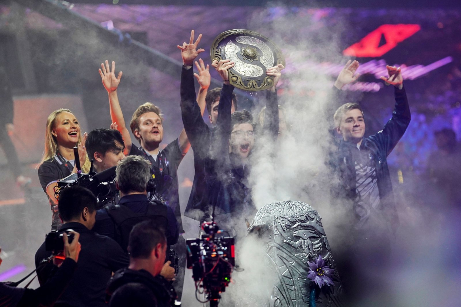 Sebastien "Ceb" Debs (C) of team OG holds the winner's trophy as the team wins the Dota 2 eSports Best of 5 final match during the International Dota 2 Championships in Shanghai on August 25, 2019. (Photo by STR / AFP) / China OUT (Photo credit should read STR/AFP/Getty Images)