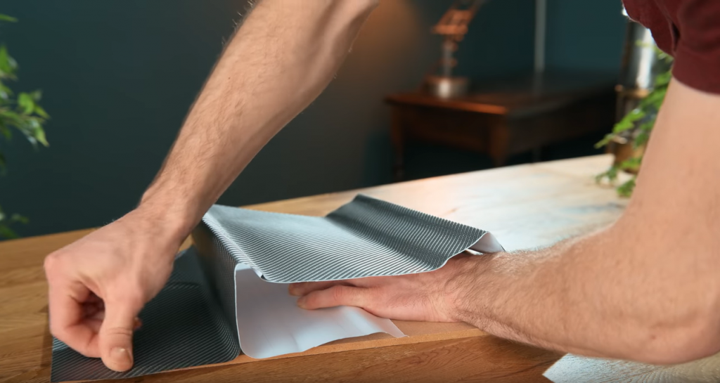 vân carbon đang được dán lên miếng gỗ trong ảnh trước