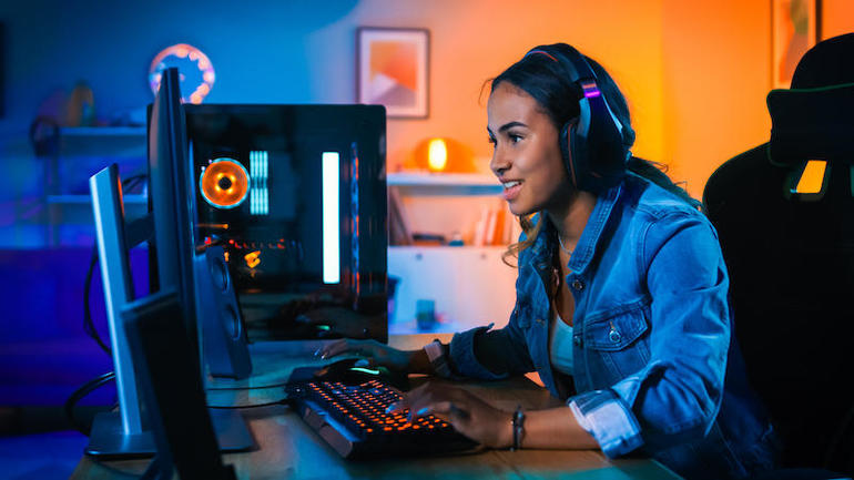 Nữ game thủ đang chơi game trong một căn phòng có ánh đèn neon rất sạch đẹp gọn gàng